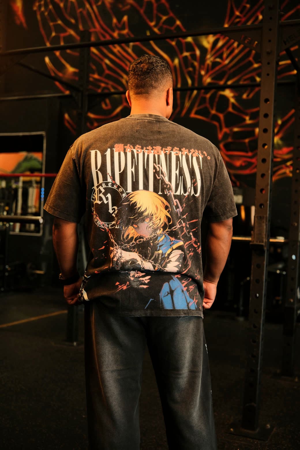 An R1P back-print tee in front of the gold phoenix mural in Waipahu
